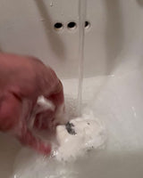 bath bomb fizzing in water leaving a white trail with some black from charcoal